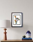 Framed artwork on a wall above a wooden console table with decorative items.